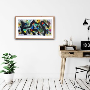 Puede incluir: Impresi&oacute;n de arte abstracto en un marco de madera con colores negro, blanco, amarillo, azul, verde y rojo. La impresi&oacute;n est&aacute; colgada en una pared blanca sobre un escritorio de madera con una planta, una l&aacute;mpara y un reloj.