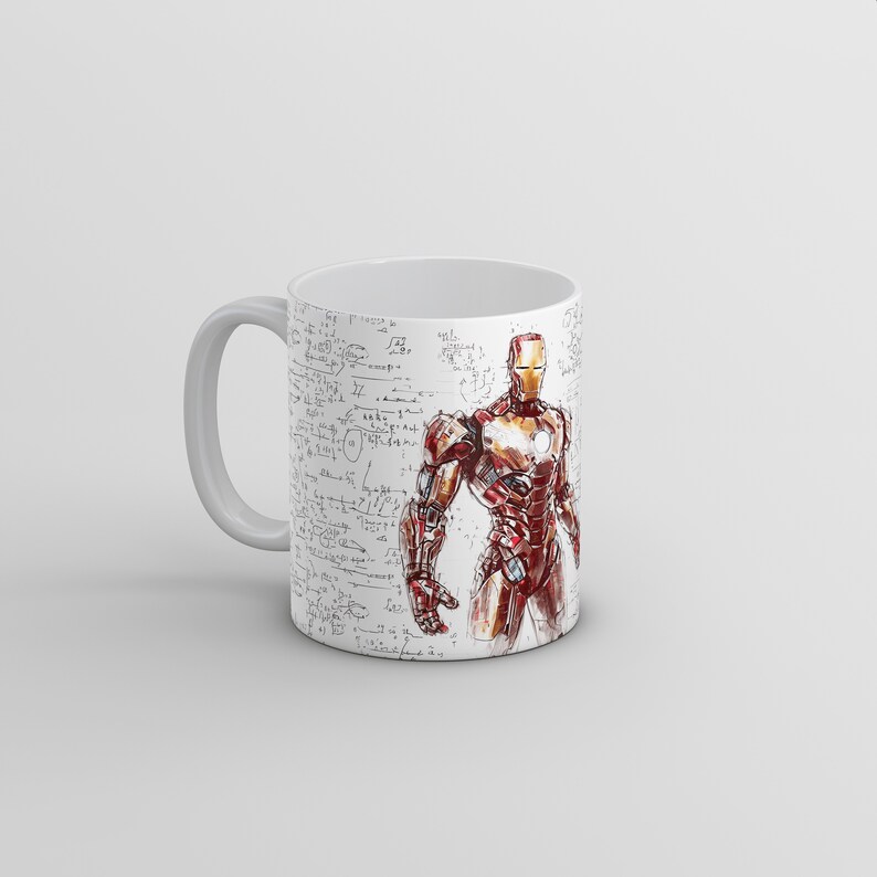 Puede incluir: Taza de cer&aacute;mica blanca con una ilustraci&oacute;n de Iron Man roja y dorada sobre un fondo blanco con garabatos negros. La taza tiene un asa negra.