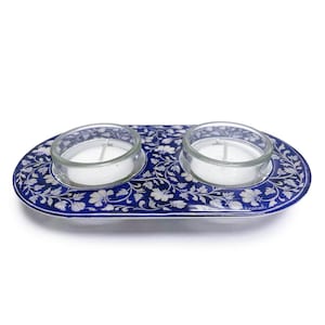 Può includere: Un portacandele ovale con un motivo floreale blu e bianco, con due portacandele in vetro trasparente. Il supporto è decorato con un motivo floreale dettagliato ed è progettato per due candele da tè.