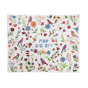 May include: White embroidered fabric with a floral design and birds. The text "ויום טוב שבת" is embroidered in blue thread.