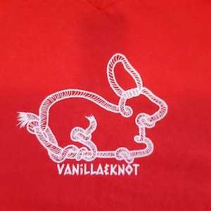 Peut inclure: T-shirt rouge avec un contour blanc d'un lapin fait de corde. Le texte "Vanilla Knot" est imprim&eacute; sous le lapin.