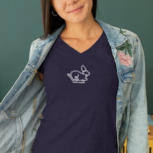 Peut inclure: Un t-shirt bleu marine &agrave; col en V avec un contour blanc d'un lapin et le texte "VanillaKnot" sur le devant.