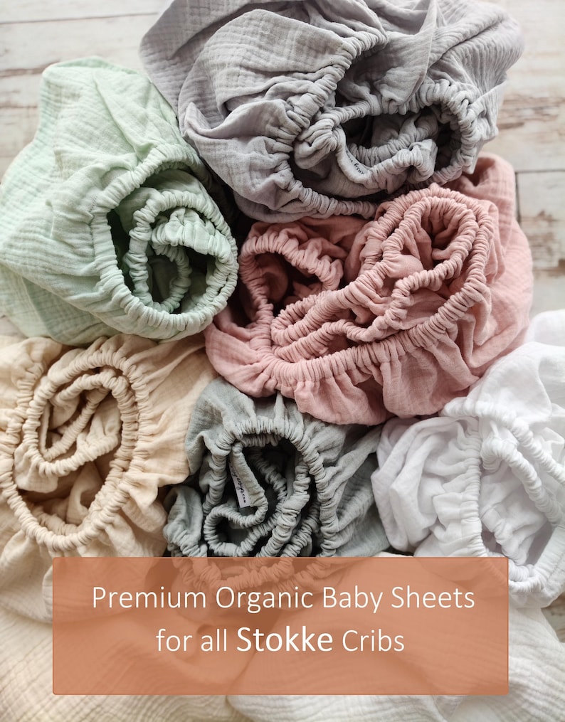 It shows fitted crib sheets made of organic muslin cotton. Perfect for baby oval or bedside cribs, bassinets and cradle. It's cozy pastel baby nursery, ideal for all Stokke cribs.