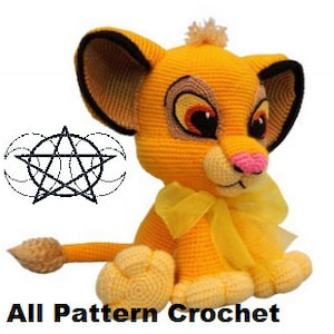 May include: Crocheted stuffed lion toy with a yellow body, brown ears, a pink nose, and a yellow bow. The lion is sitting with its paws in front of it and its tail behind it. The toy is made with yarn and is approximately 25 cm tall.