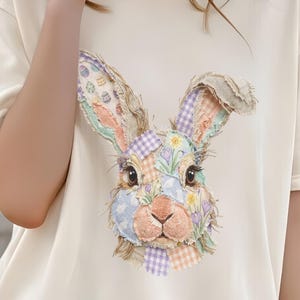May include: Cream-colored t-shirt featuring a colorful patchwork bunny face graphic. The bunny has large ears, a pink nose, and a variety of patterned patches in pastel colors. The text "Visual Sensei" is in the bottom left corner.