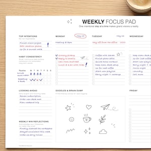 Pode incluir: Um Weekly Focus Pad branco com seções para intenções, hábitos e rabiscos. Possui um cronograma de segunda a sexta-feira com caixas de seleção para tarefas. O bloco é projetado para planejamento e organização.
