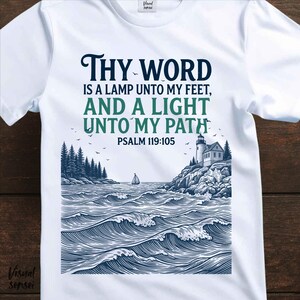 May include: White t-shirt with a graphic design featuring a lighthouse on a rocky coast, waves, and a sailboat. The text reads "THY WORD IS A LAMP UNTO MY FEET, AND A LIGHT UNTO MY PATH, PSALM 119:105."