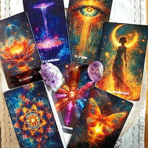 Könnte beinhalten: Eine Sammlung von Tarotkarten mit lebendigen, kosmischen Kunstwerken. Die Karten zeigen Bilder einer Lotusblume, eines Auges, eines Schmetterlings und anderer mystischer Szenen. Der Text auf den Karten enthält Sätze wie "La vision" und "La transformation". Amethystkristalle sind ebenfalls vorhanden.