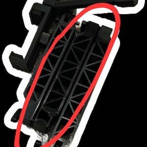 May include: A black plastic phone mount featuring a central support arm with a visible triangular truss structure. The mount includes an adjustable clamp mechanism at the top and a hinged joint at the base, designed for securing a mobile device.