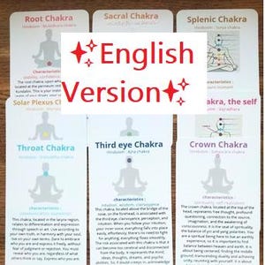Peut inclure: Un ensemble de cartes rectangulaires blanches présentant des informations sur les chakras. Chaque carte affiche la silhouette d'une personne en position de méditation assise avec un point de chakra coloré et des étiquettes textuelles.