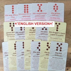 Puede incluir: Una baraja de cartas de tarot con varios títulos y descripciones. Las cartas tienen un fondo color crema con puntos y texto marrones. Las palabras "ENGLISH VERSION" están impresas en una de las cartas.