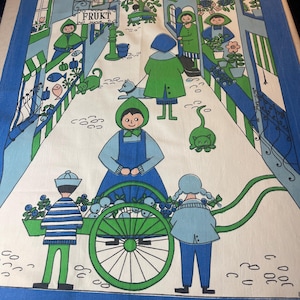 Puede incluir: Una tela vintage azul y blanca con una ilustración caprichosa de una escena de mercado. El diseño incluye figuras, gatos y un carro lleno de productos. La palabra "FRUKT" es visible en la imagen.