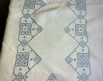 Hand-embroidered tablecloth on a pink background