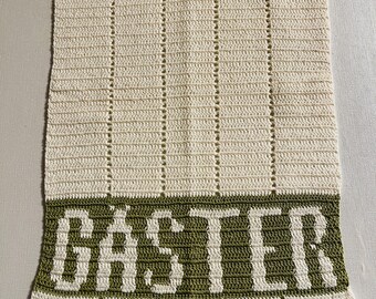 Hand crocheted guest towel with the text guests in Swedish: Crocheted in white and green with the text in white