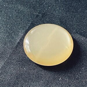 Vintage button that is yellow colored with luster