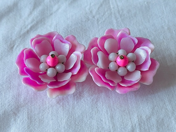 A pair of larger vintage 1950s period pink flower shaped plastic ear clips with metal clips.