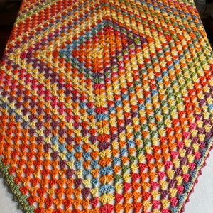 Hand-crocheted square cloth in several different colors such as yellow, orange, blue, green and more