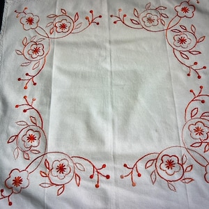 Hand-embroidered table cloth with pink tones