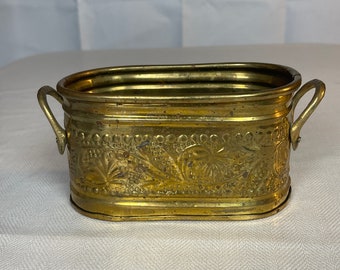 Oval pot with brass handle   The label underneath says Genuine brass