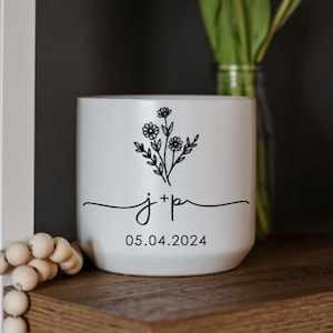 Könnte beinhalten: Weiße Keramiktasse mit schwarzem Blumendesign und dem Text "j+p 05.04.2024".