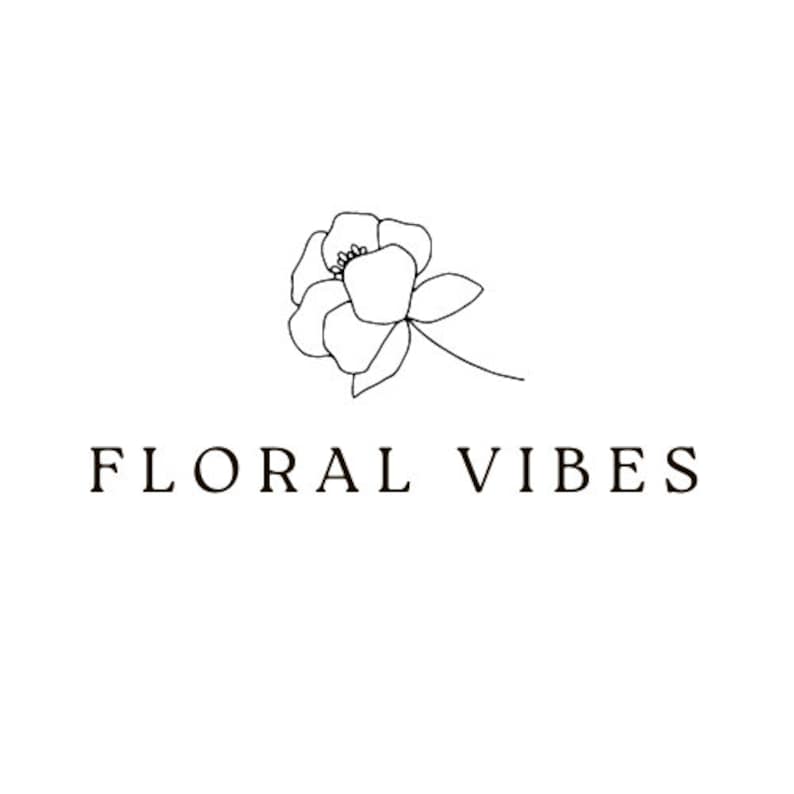 May include: A minimalist logo design featuring a delicate line drawing of a flower above the words "FLORAL VIBES" in a serif font. The design is in black and white, set against a clean white background, suitable for floral-themed products.