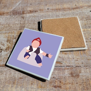 May include: A purple ceramic coaster with a white border features a cartoon illustration of a child wearing a red pirate hat and a black vest. The child is sitting on a white cloud.
