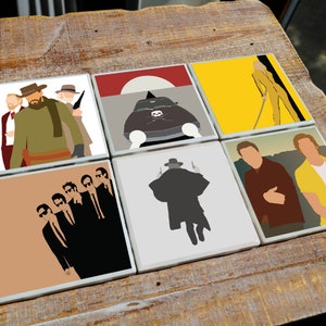 May include: Six different coasters featuring iconic movie characters and scenes. The coasters are square and made of ceramic. The characters include a group of men in suits, a man in a long coat, a woman in a yellow jumpsuit, and a car with a skull and crossbones.