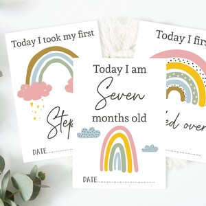 May include: Three printable milestone cards with rainbow illustrations and text. The first card says "Today I took my first step". The second card says "Today I am seven months old". The third card says "Today I first rolled over".