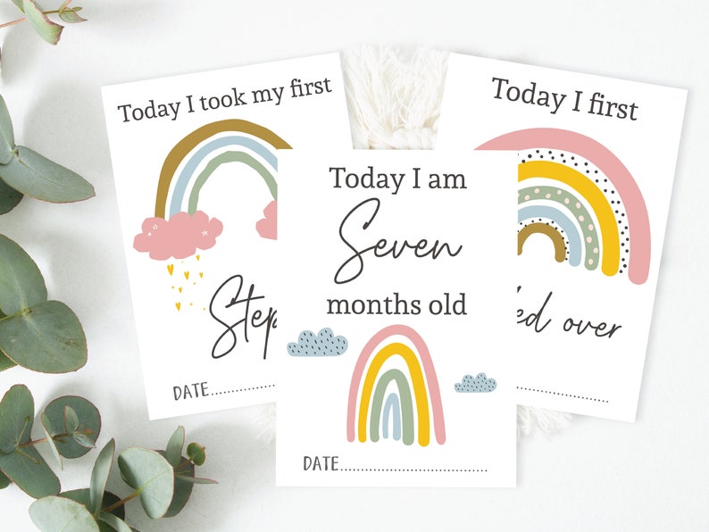 May include: Three printable milestone cards with rainbow illustrations and text. The first card says "Today I took my first step". The second card says "Today I am seven months old". The third card says "Today I first rolled over".