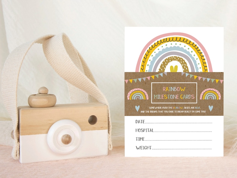 May include: Rainbow milestone cards featuring a colourful rainbow design and the text "Somewhere over the rainbow, skies are blue and the dreams that you dare to dream really do come true". The cards have spaces to record the date, hospital, time, and weight.