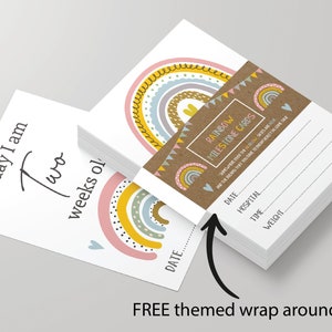 May include: A stack of rainbow milestone cards with a brown paper wrap around. The cards feature a rainbow design with yellow, pink, blue, and green colours. The wrap around has the text "Rainbow Milestone Cards" and a smaller rainbow design.