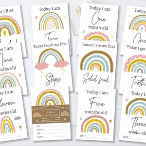 May include: Set of ten rainbow milestone cards for a baby. Each card features a rainbow with different colours and patterns, and a milestone message. The messages include "Today I am One month old", "Today I am Nine months old", "Today I am Eleven months old", "Today I am Three weeks old", "Today I am Five months old", "Today I am One", "Today I got my first Tooth", "Today I ate my first Solid food", "Today I took my first Steps", and "Today I first".