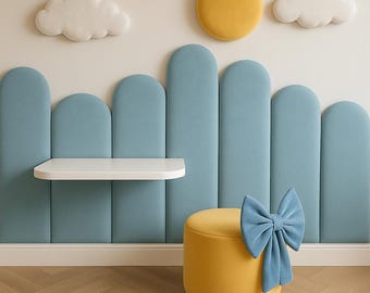 Puede incluir: Diseño de habitación infantil caprichoso con un otomán amarillo con un lazo azul, una estantería blanca y paneles de pared azules. Nubes decorativas y un sol amarillo adornan la pared, creando un ambiente lúdico.