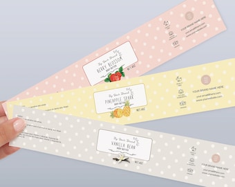 May include: Three labels for body butter jars with a polka dot background. The labels are in pink, yellow, and gray. The labels feature illustrations of berries, pineapple, and vanilla bean. The text on the labels reads "Berry Blossom", "Pineapple Spark", and "Vanilla Bean".
