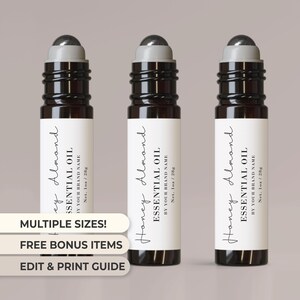 Könnte beinhalten: Drei Glas-Rollflaschen mit schwarzen Roll-on-Kappen und weißen Etiketten. Die Etiketten tragen schwarzen Text mit der Aufschrift "Honey Almond Essential Oil, By Your Brand Name, Net. 1oz/28g".