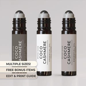 Könnte beinhalten: Drei Glas-Rollflaschen mit schwarzen Deckeln und Etiketten. Die Etiketten sind weiß, grau und braun mit schwarzem Text, der "BRAND NAME COCO CASHMERE ESSENTIAL OIL cocoa + lavender" lautet.