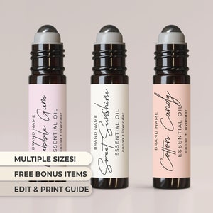 May include: Three glass roller bottles with black lids and labels. The labels are white, pink, and light pink with black text. The text on the labels reads "Bubble Gum Essential Oil cocoa + lavender", "Sweet Sunshine Essential Oil cocoa + lavender", and "Cotton Candy Essential Oil cocoa + lavender".