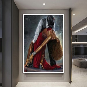 May include: A painting of a couple dancing. The man is wearing a black hat and a white shirt, and the woman is wearing a red dress. The background is a dark gray wall.