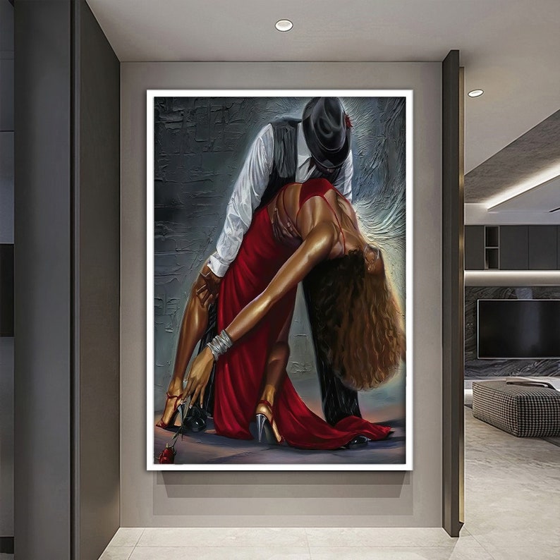 May include: A painting of a couple dancing. The man is wearing a black hat and a white shirt, and the woman is wearing a red dress. The background is a dark gray wall.