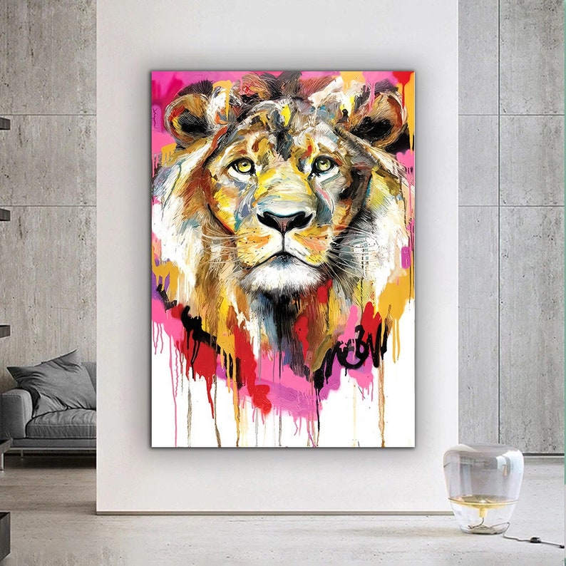 May include: A colorful abstract painting of a lion's face with splashes of pink, yellow, red, and blue paint.