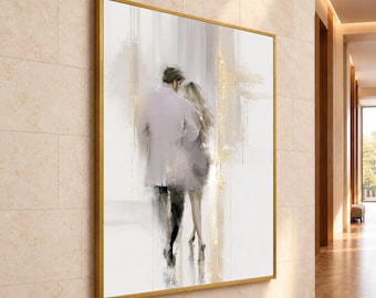 May include: A large square wall art piece in a gold frame featuring an abstract painting of two figures walking away. The figures are rendered in soft white, gray, and black tones with subtle gold leaf accents against a bright white background.