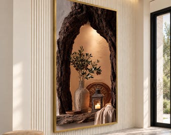May include: A rectangular wall art piece in a gold frame featuring a dark, textured tree trunk archway. Inside the arch, a beige vase holds an olive branch, next to a dark metal lantern with a lit candle and a draped light fabric.