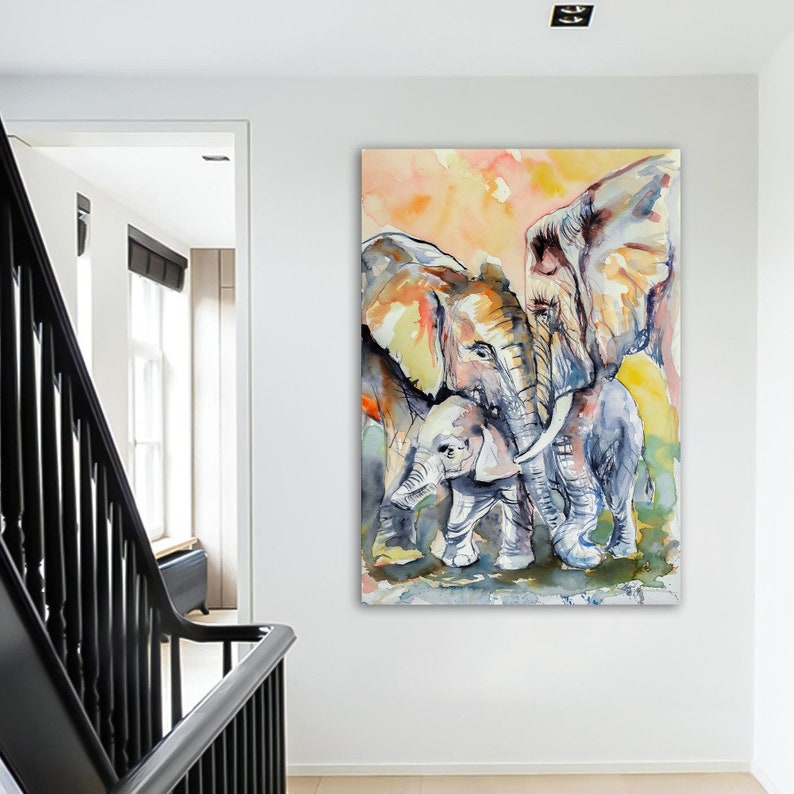 May include: A watercolor painting of three elephants. Two large elephants are standing side-by-side, with a smaller elephant standing in front of them. The elephants are painted in shades of gray, brown, and yellow, with a soft, watercolor background.
