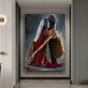 May include: A painting of a couple dancing. The woman is wearing a red dress and the man is wearing a black suit. The background is a gray wall with a textured surface.