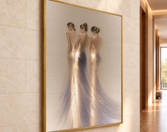 May include: A framed wall art piece featuring three figures standing with their backs to the viewer, wearing long, flowing gowns that transition into shimmering, golden, light-filled textures against a neutral, light-toned background.