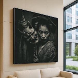 May include: Black and white framed artwork featuring a woman in traditional Japanese attire holding a demon mask and a sword. The artwork is displayed on a beige wall above a cream-colored sofa, with a window to the right.