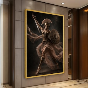 May include: A framed wall art print depicting a warrior figure in bronze armor and a plumed helmet, holding a sword aloft and carrying a circular shield. The figure wears flowing, translucent fabric that drapes around the body against a dark background.