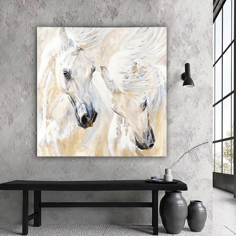 Op de afbeelding: Een schilderij van twee witte paarden met hun hoofden bij elkaar. De paarden zijn geschilderd in een zachte, abstracte stijl met een witte achtergrond en hints van goud en grijs.