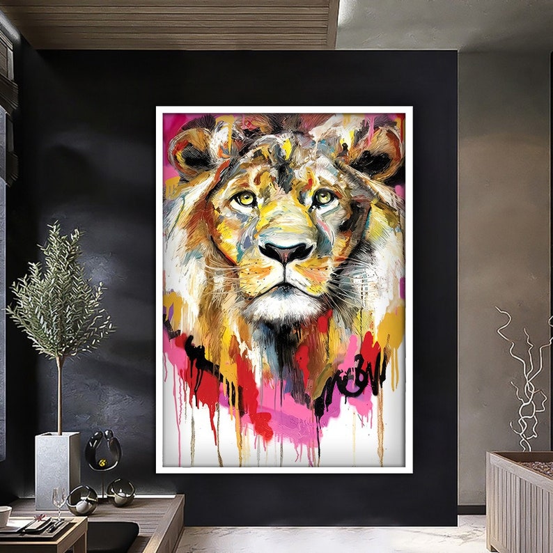 May include: A colorful abstract painting of a lion's face with a pink, red, and yellow background. The lion's fur is painted in shades of brown, yellow, and orange.