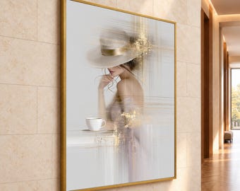 May include: A framed wall art print featuring a person wearing a wide-brimmed hat, holding a white coffee cup. The image uses a light color palette with abstract gold foil-like horizontal streaks and blurred lines across the composition.